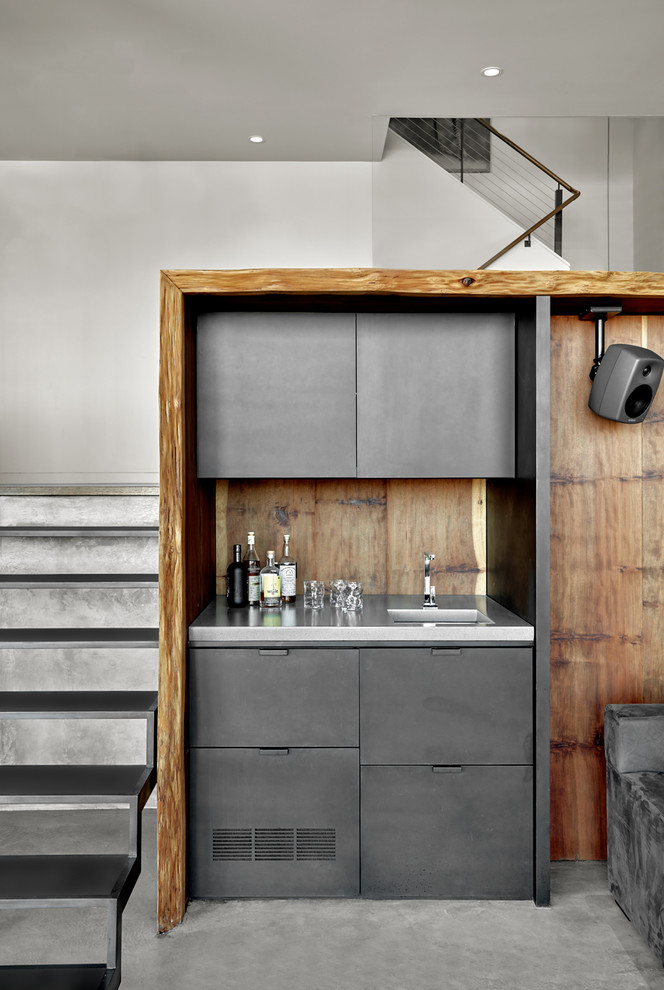 Modern inredning av en mellanstor linjär hemmabar med vask, med betonggolv, grått golv, en integrerad diskho, släta luckor, grå skåp, bänkskiva i rostfritt stål, brunt stänkskydd och stänkskydd i trä