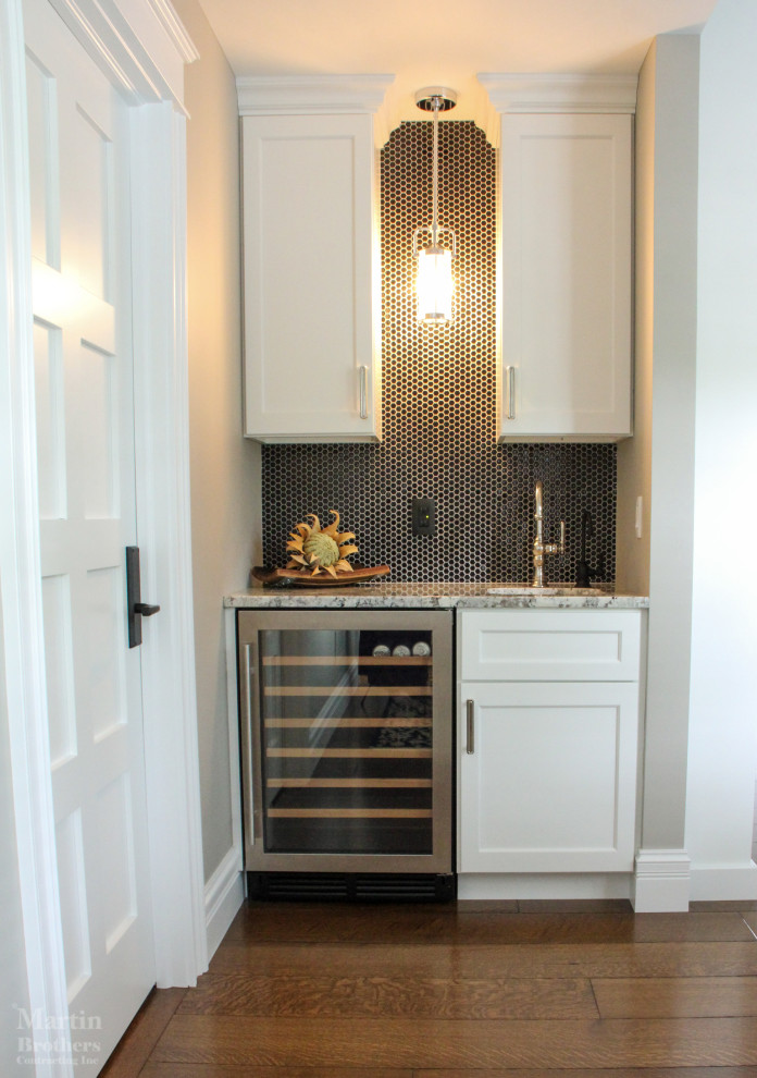 Inspiration for a small traditional single-wall wet bar in Other with a submerged sink, shaker cabinets, white cabinets, granite worktops, black splashback, ceramic splashback and medium hardwood flooring.