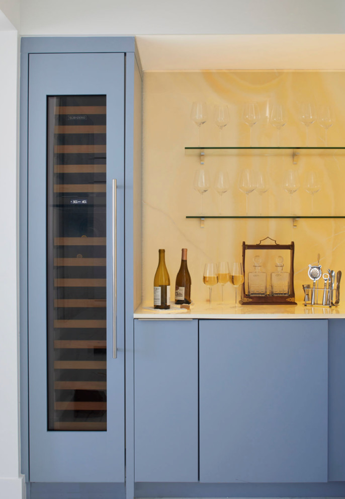 Imagen de bar en casa lineal contemporáneo de tamaño medio con armarios con paneles lisos, puertas de armario azules, encimera de mármol y salpicadero de mármol