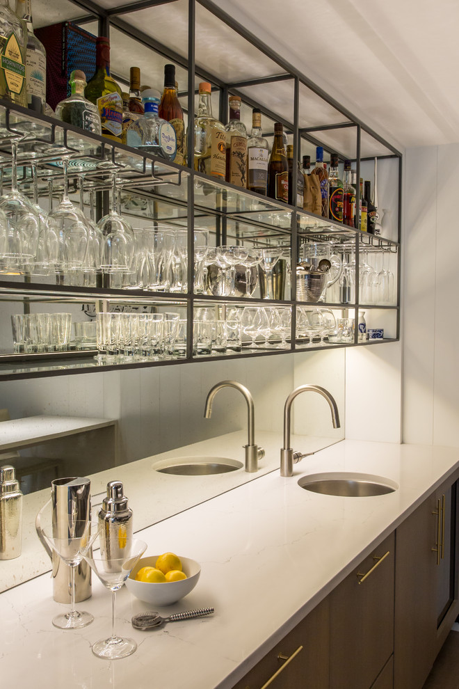 Idee per un bancone bar moderno di medie dimensioni con lavello sottopiano, ante lisce, ante grigie, top in quarzo composito, paraspruzzi a specchio e top bianco