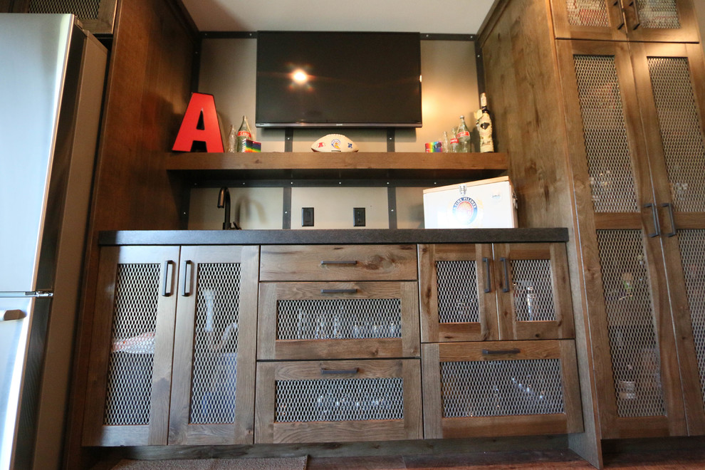 Aménagement d'un bar de salon linéaire industriel en bois foncé de taille moyenne avec des tabourets, un évier encastré, un plan de travail en granite, une crédence grise et un sol en vinyl.