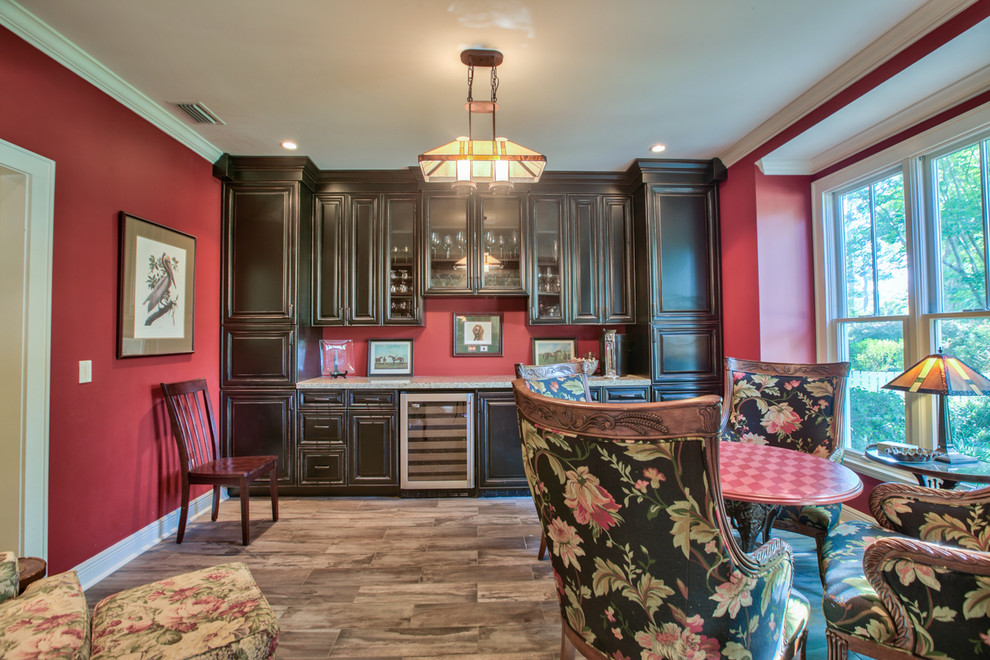 Photo of a medium sized traditional single-wall wet bar in Atlanta with a submerged sink, raised-panel cabinets, black cabinets, granite worktops, dark hardwood flooring, brown floors and white worktops.