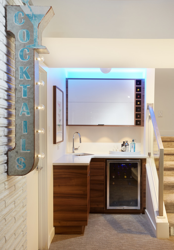 Photo of a contemporary l-shaped wet bar in Edmonton with a submerged sink, flat-panel cabinets, medium wood cabinets, engineered stone countertops, white splashback, ceramic splashback and carpet.
