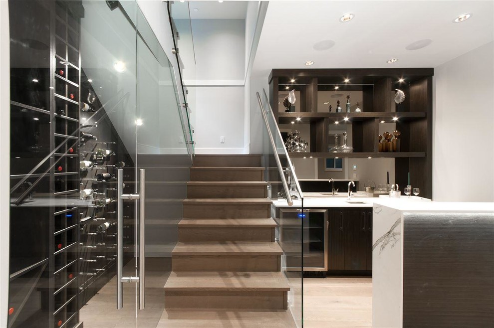 Contemporary single-wall wet bar in Vancouver with a submerged sink, open cabinets, dark wood cabinets, mirror splashback and light hardwood flooring.