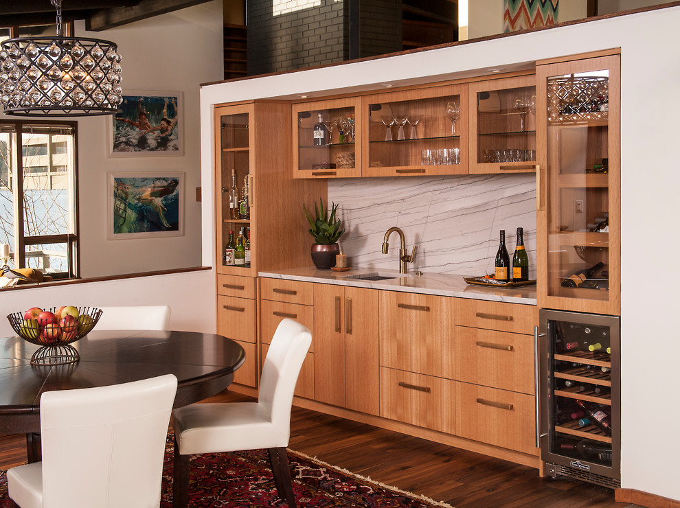 This is an example of a medium sized contemporary single-wall wet bar in Seattle with a submerged sink, flat-panel cabinets, light wood cabinets, wood worktops, grey splashback, stone slab splashback, porcelain flooring, grey floors and grey worktops.
