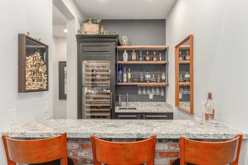 Example of a transitional galley seated home bar design in Phoenix with an undermount sink, raised-panel cabinets, distressed cabinets and gray backsplash
