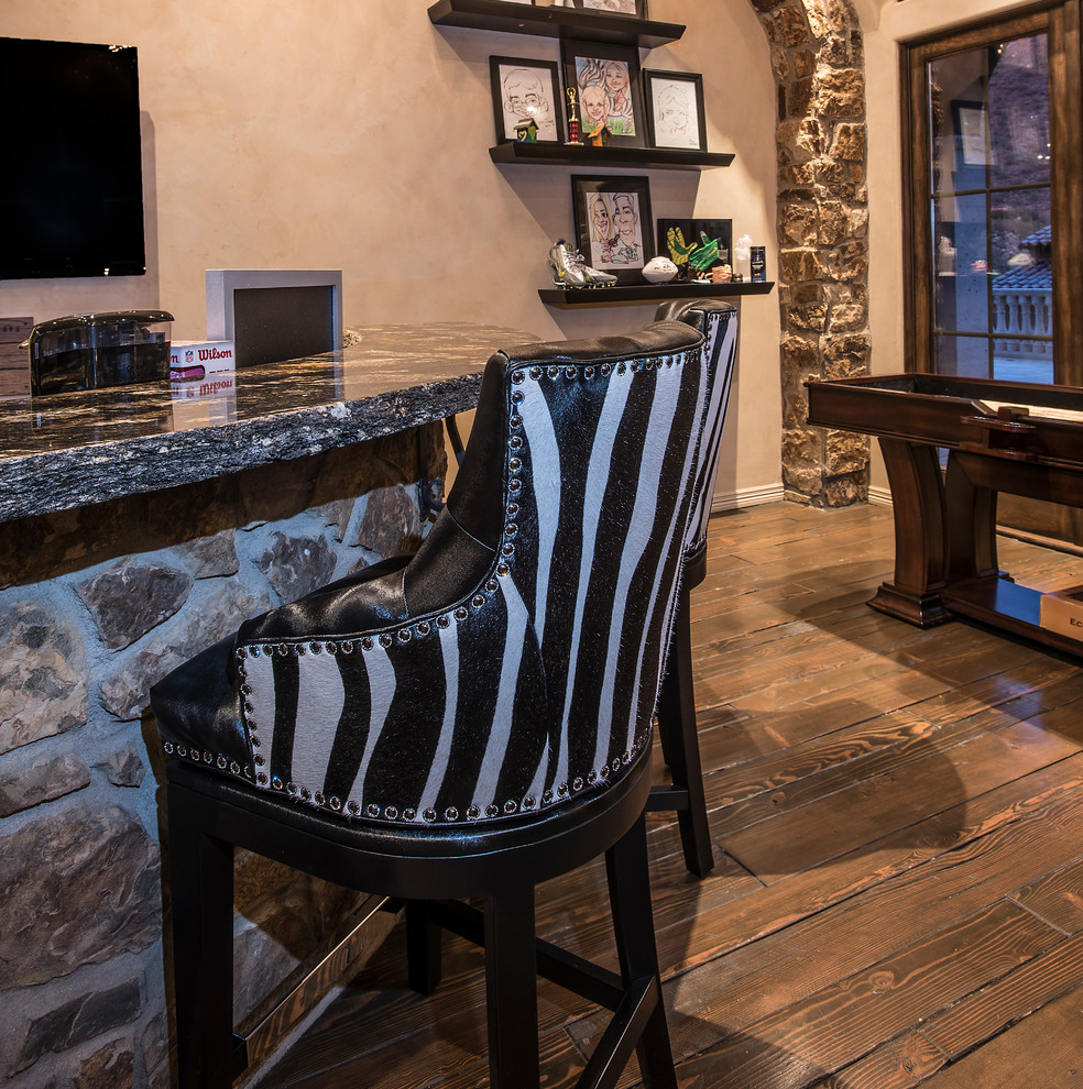 Ejemplo de bar en casa con barra de bar mediterráneo de tamaño medio con suelo de madera oscura y suelo marrón