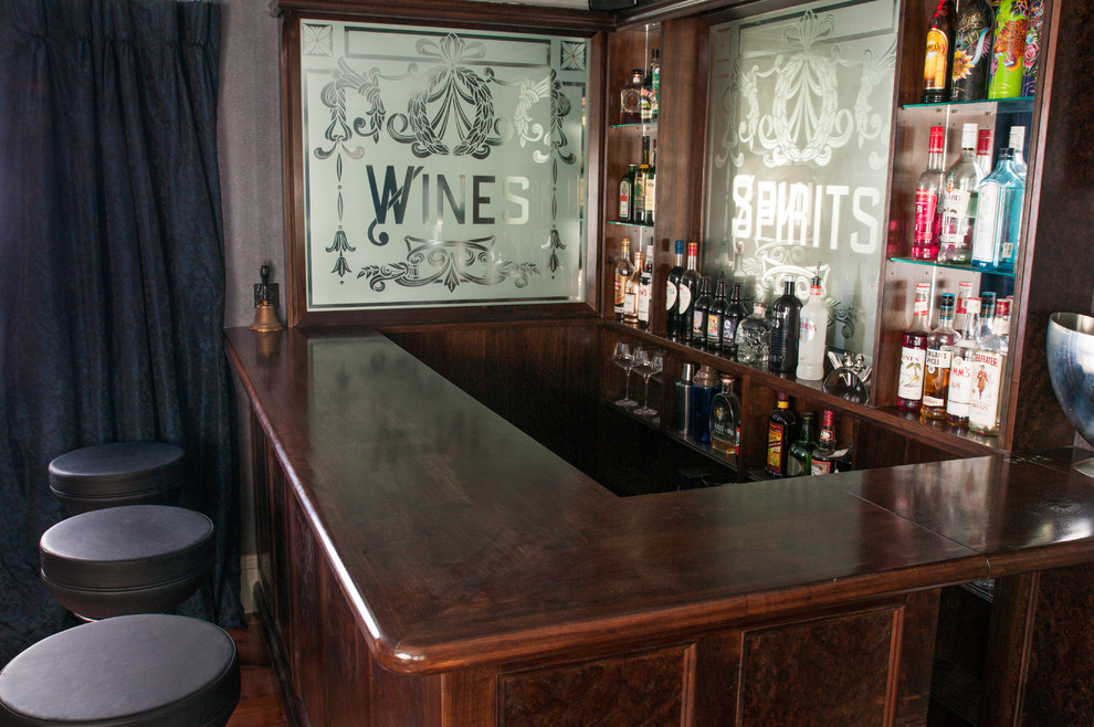 Idee per un piccolo angolo bar tradizionale con ante a filo, ante in legno bruno e top in legno