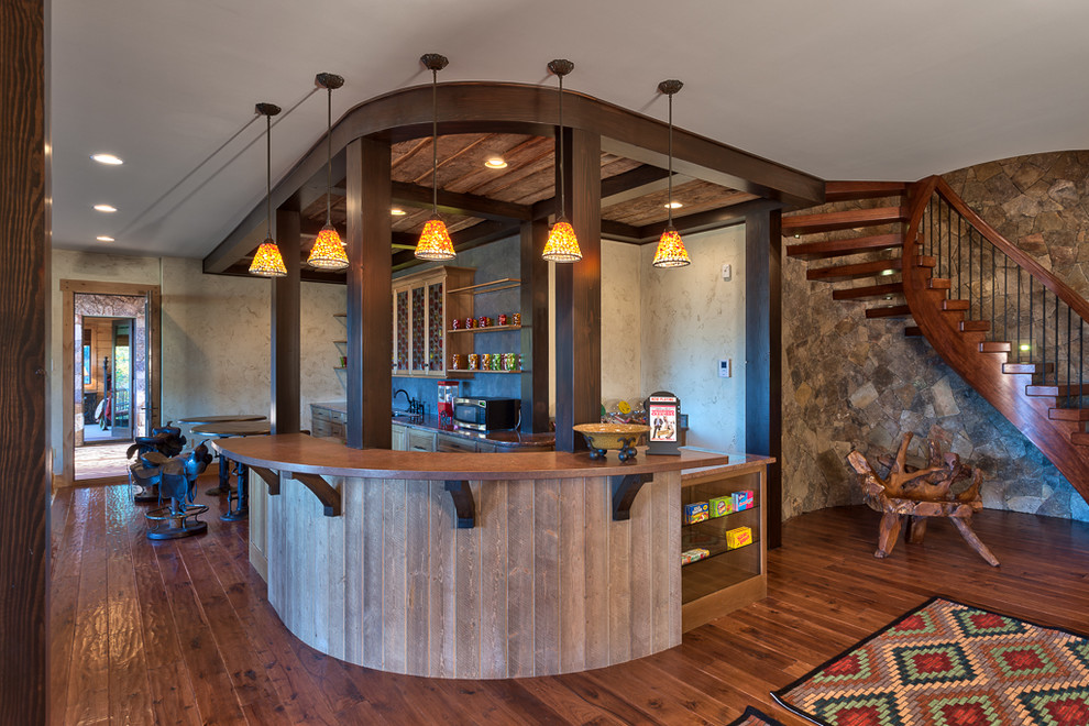 Idee per un bancone bar stile rurale con lavello sottopiano, ante in legno scuro, paraspruzzi grigio e pavimento in legno massello medio