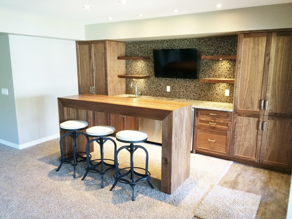 Aménagement d'un petit bar de salon avec évier parallèle moderne en bois brun avec un évier encastré, un placard à porte shaker, un plan de travail en granite, une crédence en mosaïque et moquette.