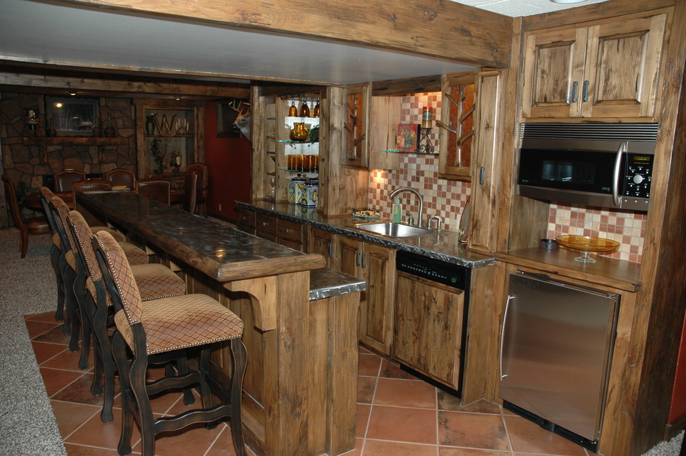 Photo of a large rustic galley breakfast bar in Wichita with an integrated sink, raised-panel cabinets, light wood cabinets, zinc worktops, multi-coloured splashback, mosaic tiled splashback, terracotta flooring, red floors and grey worktops.