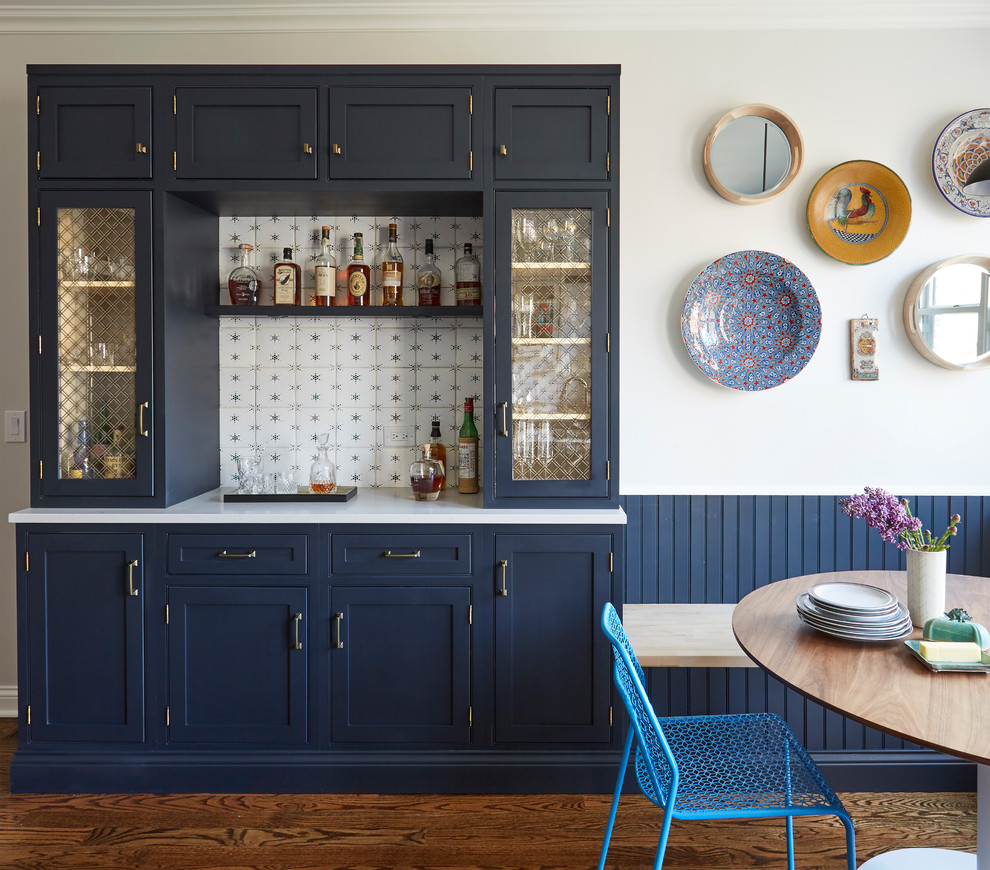 Example of a country single-wall dark wood floor and brown floor home bar design in Chicago with shaker cabinets, blue cabinets and multicolored backsplash