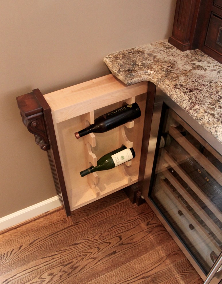 Photo of a medium sized traditional single-wall wet bar with a submerged sink, beaded cabinets, dark wood cabinets, granite worktops and medium hardwood flooring.