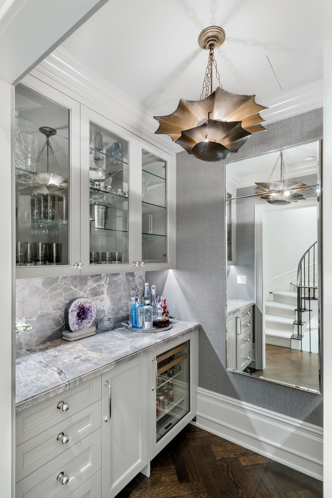 Kleine, Einzeilige Klassische Hausbar mit Glasfronten, weißen Schränken, Küchenrückwand in Grau, dunklem Holzboden und braunem Boden in New York
