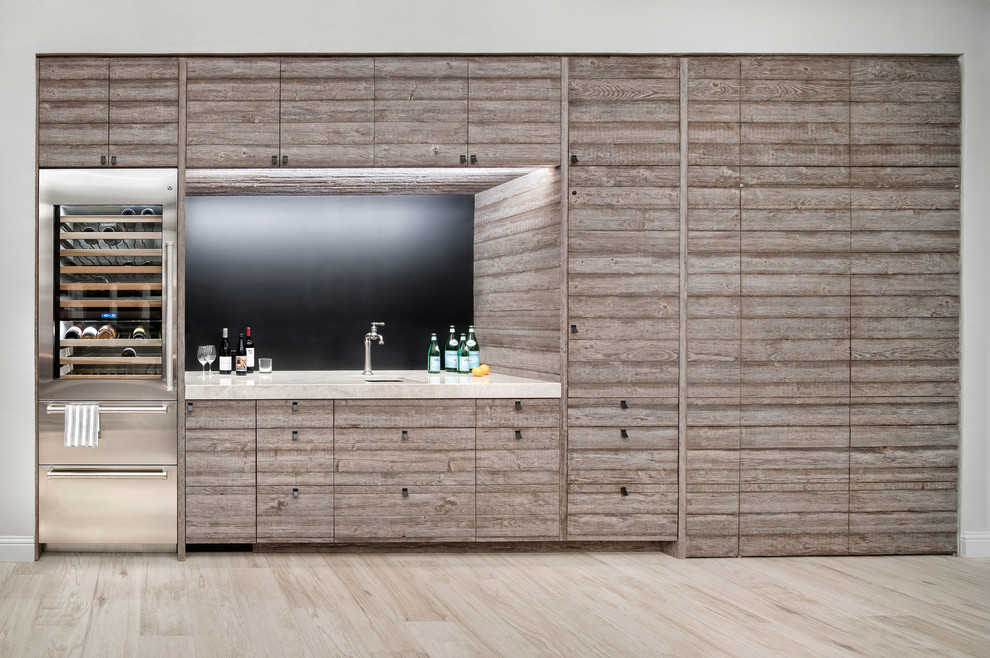 This is an example of a contemporary single-wall wet bar in Austin with a submerged sink, flat-panel cabinets, porcelain flooring and beige floors.