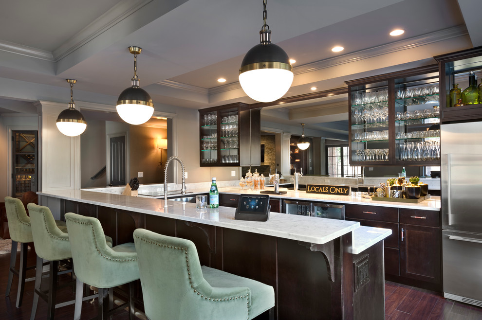 Foto di un grande bancone bar classico con ante di vetro, ante in legno bruno, top in marmo, parquet scuro e pavimento marrone