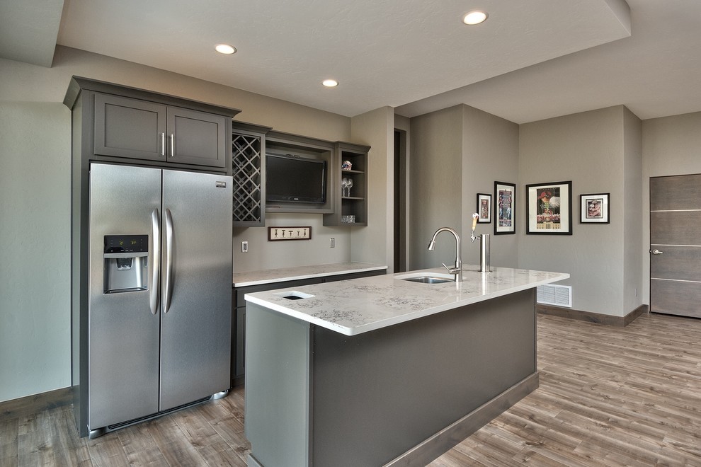 Small contemporary single-wall open plan kitchen in Denver with a submerged sink, shaker cabinets, grey cabinets, marble worktops, stainless steel appliances, light hardwood flooring, an island and brown floors.