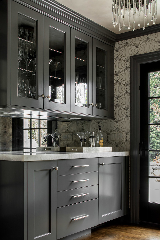 Foto på en mellanstor vintage parallell hemmabar med vask, med en undermonterad diskho, grå skåp, marmorbänkskiva, mörkt trägolv, brunt golv, spegel som stänkskydd och luckor med infälld panel