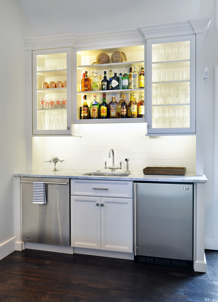 Inspiration for a small traditional single-wall home bar in Charleston with dark hardwood flooring, a submerged sink, recessed-panel cabinets, white cabinets, marble worktops, white splashback, metro tiled splashback and white worktops.