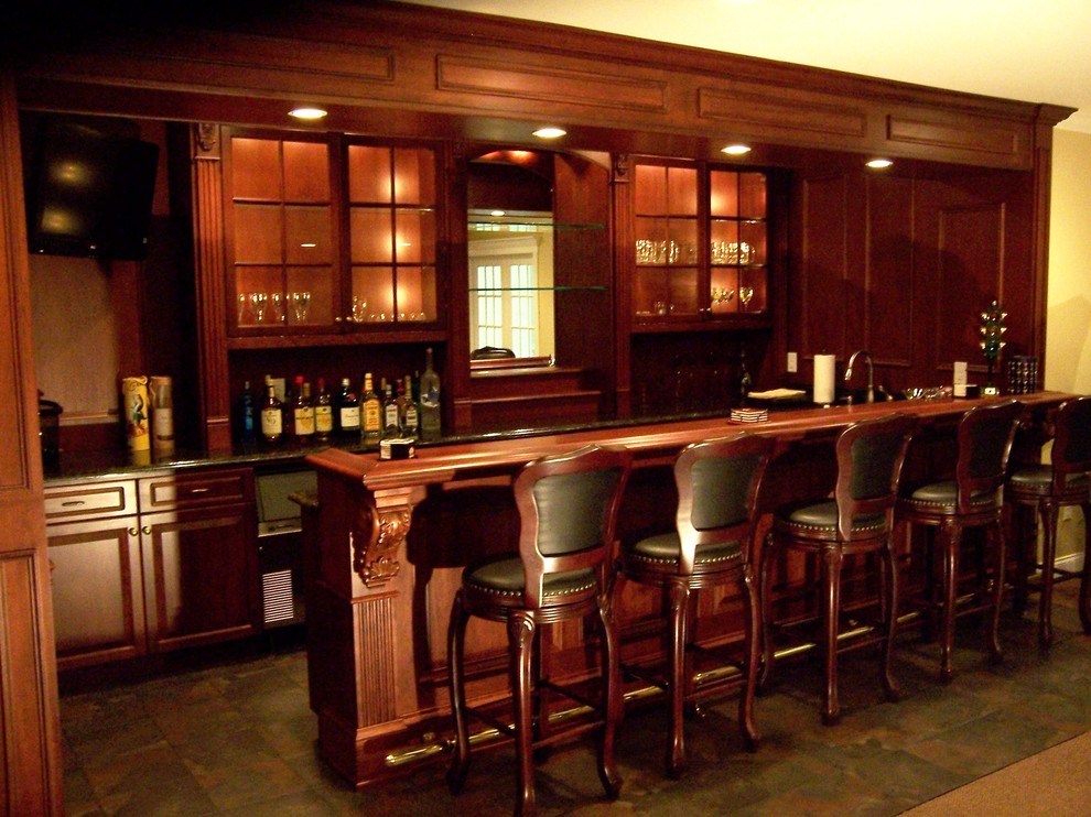 Idee per un grande bancone bar tradizionale con pavimento marrone, ante di vetro, ante in legno scuro e top in legno