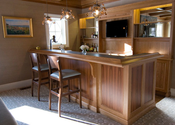 Aménagement d'un bar de salon avec évier linéaire en bois brun avec un placard avec porte à panneau encastré, un plan de travail en stratifié et moquette.