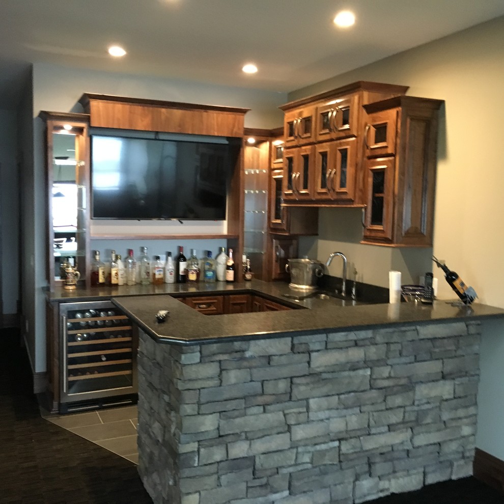Example of a mid-sized u-shaped wet bar design in Minneapolis with glass-front cabinets, gray cabinets and granite countertops