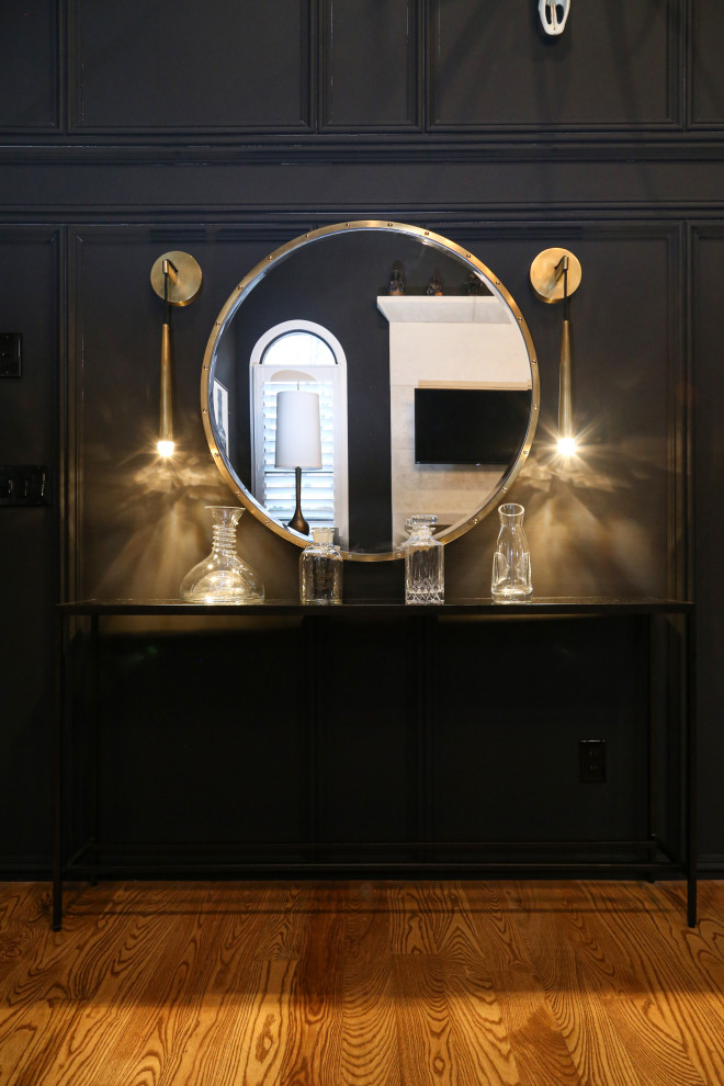 Ejemplo de bar en casa clásico renovado de tamaño medio con puertas de armario de madera en tonos medios, encimera de cuarzo compacto, suelo de madera clara y encimeras negras