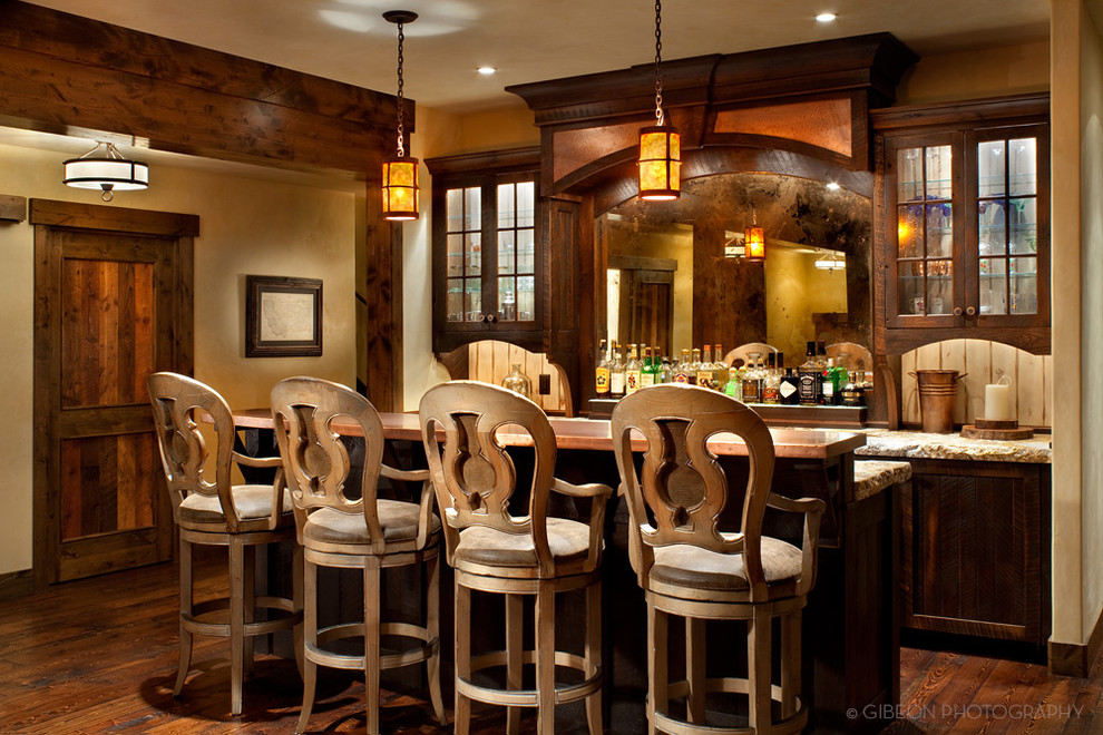 Immagine di un grande bancone bar rustico con ante in stile shaker, ante in legno bruno, top in granito, paraspruzzi bianco, paraspruzzi in legno e parquet scuro