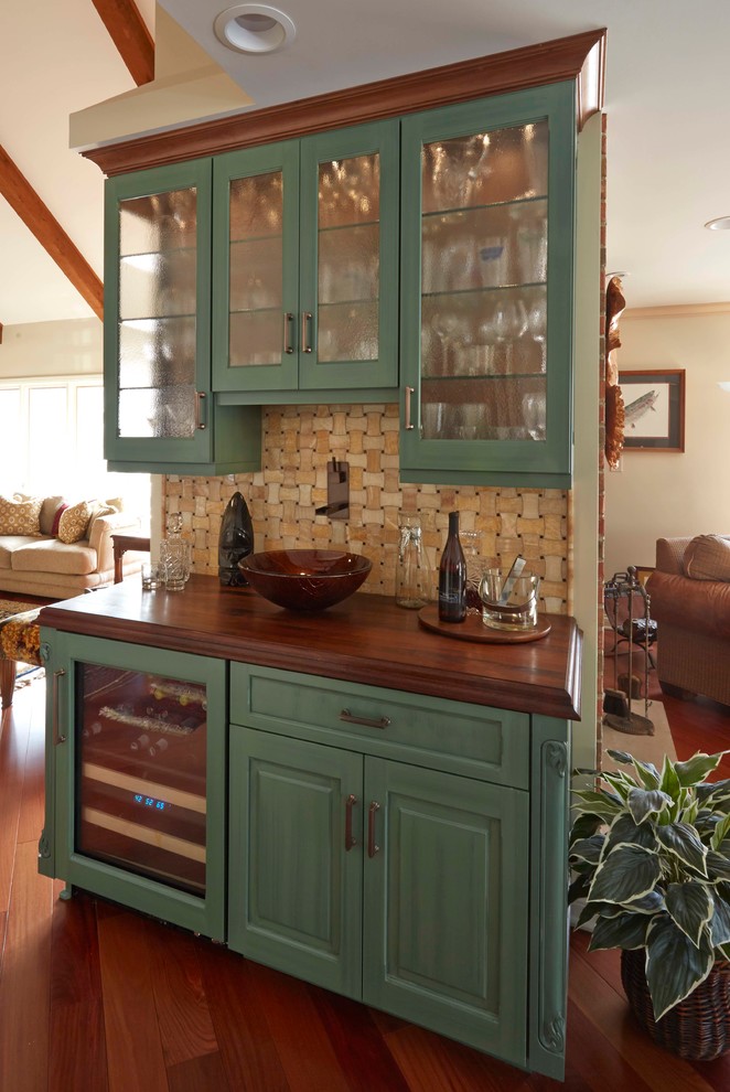Bild på en mellanstor vintage linjär hemmabar med vask, med luckor med glaspanel, gröna skåp, träbänkskiva, brunt stänkskydd, stänkskydd i keramik, mellanmörkt trägolv och brunt golv