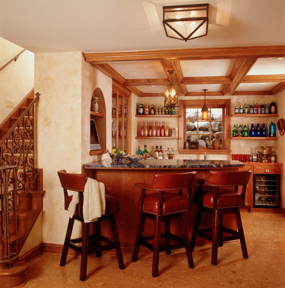 Foto di un bancone bar tradizionale di medie dimensioni con lavello da incasso, nessun'anta, ante in legno scuro, top in granito, paraspruzzi beige e pavimento in sughero