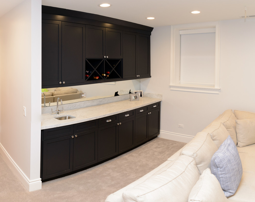 This is an example of a small contemporary u-shaped wet bar in Chicago with marble worktops, a submerged sink, shaker cabinets, dark wood cabinets, mirror splashback and carpet.