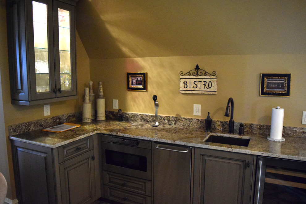 This is an example of a small classic l-shaped wet bar in Charlotte with a submerged sink, beaded cabinets, medium wood cabinets, granite worktops and carpet.