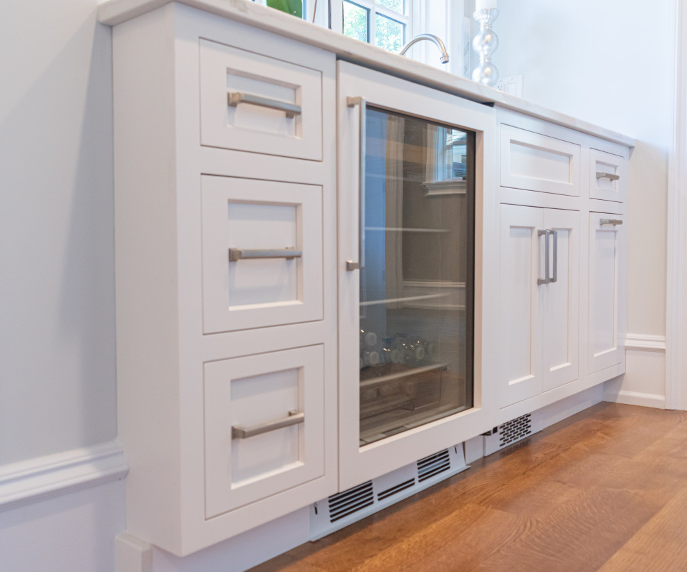 Inspiration for a medium sized traditional single-wall wet bar in Philadelphia with a submerged sink, recessed-panel cabinets, white cabinets, quartz worktops, white splashback, marble splashback, medium hardwood flooring, brown floors and white worktops.