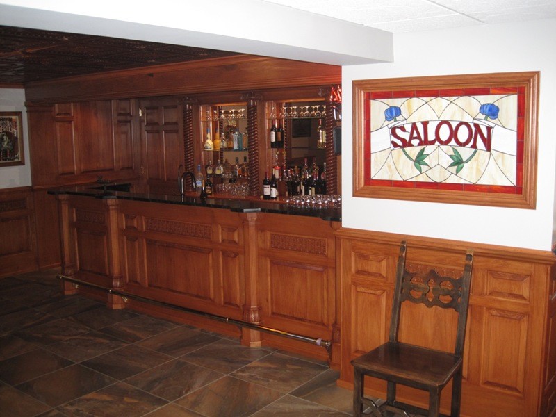 Diseño de bar en casa con fregadero tradicional grande con armarios con paneles con relieve, puertas de armario de madera oscura, encimera de granito y suelo de pizarra
