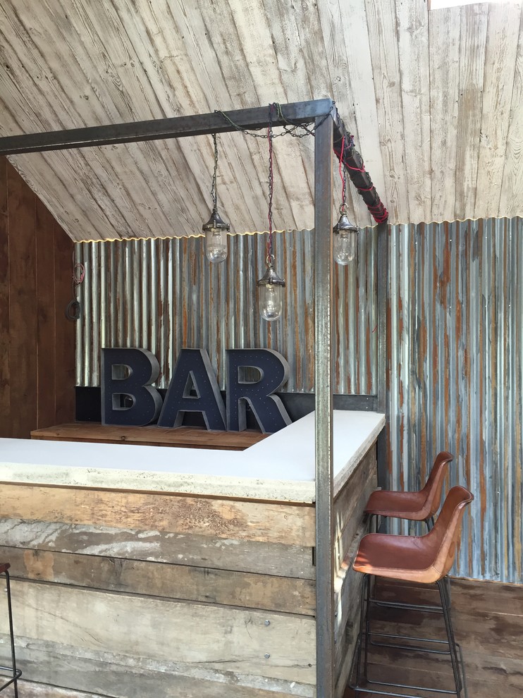 На фото: угловой домашний бар в стиле рустика с барной стойкой и темным паркетным полом