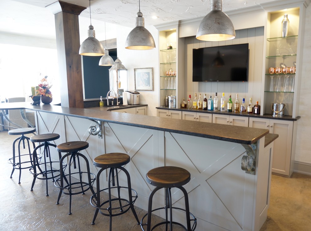 Photo of a large classic l-shaped wet bar in Cleveland with white cabinets, concrete flooring and shaker cabinets.