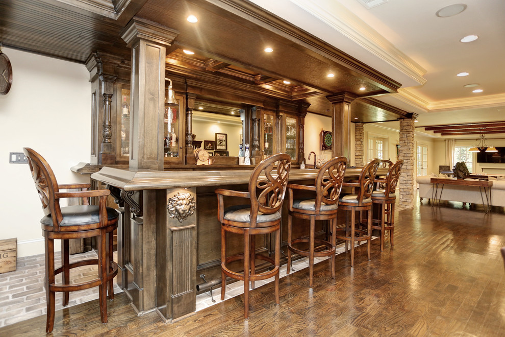 Immagine di un grande bancone bar tradizionale con lavello sottopiano, ante con riquadro incassato, ante in legno bruno, top in granito, pavimento in mattoni e pavimento grigio