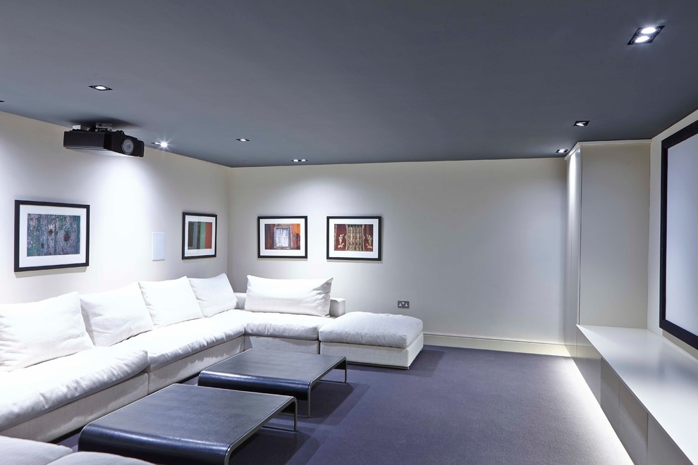 Cette image montre une salle de cinéma design de taille moyenne et fermée avec un mur blanc, moquette et un écran de projection.