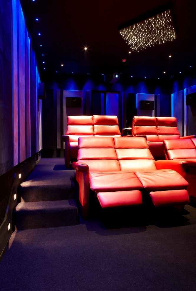 На фото: большой изолированный домашний кинотеатр в современном стиле с черными стенами, ковровым покрытием и мультимедийным центром с