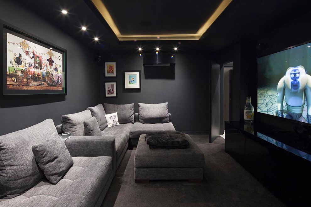 На фото: изолированный домашний кинотеатр среднего размера в современном стиле с черными стенами, ковровым покрытием, мультимедийным центром и серым полом