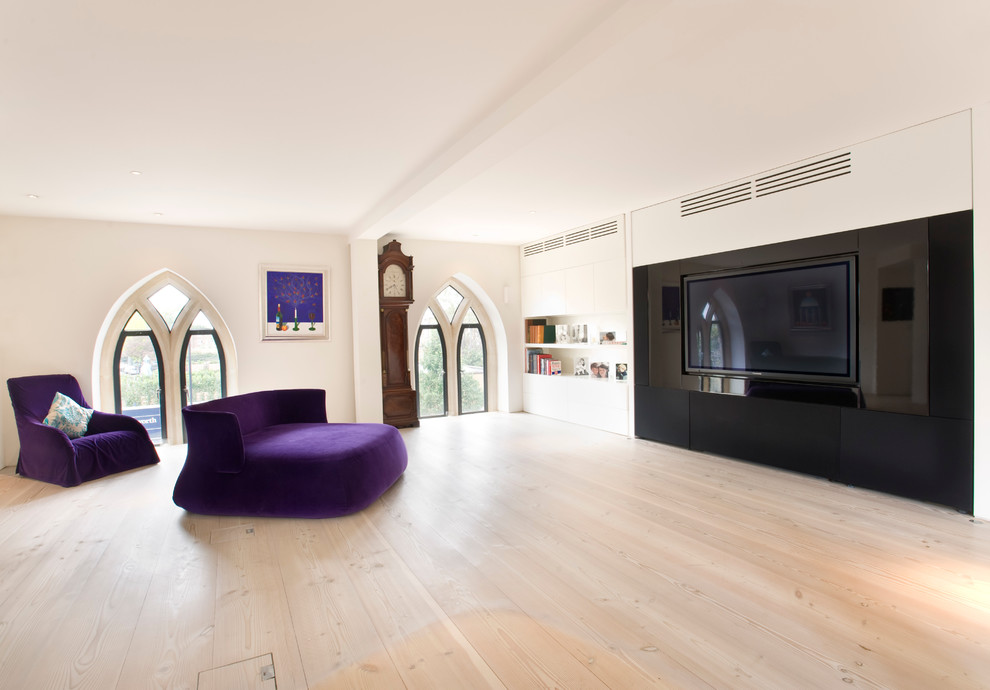 Источник вдохновения для домашнего уюта: домашний кинотеатр в скандинавском стиле с белыми стенами, светлым паркетным полом и телевизором на стене