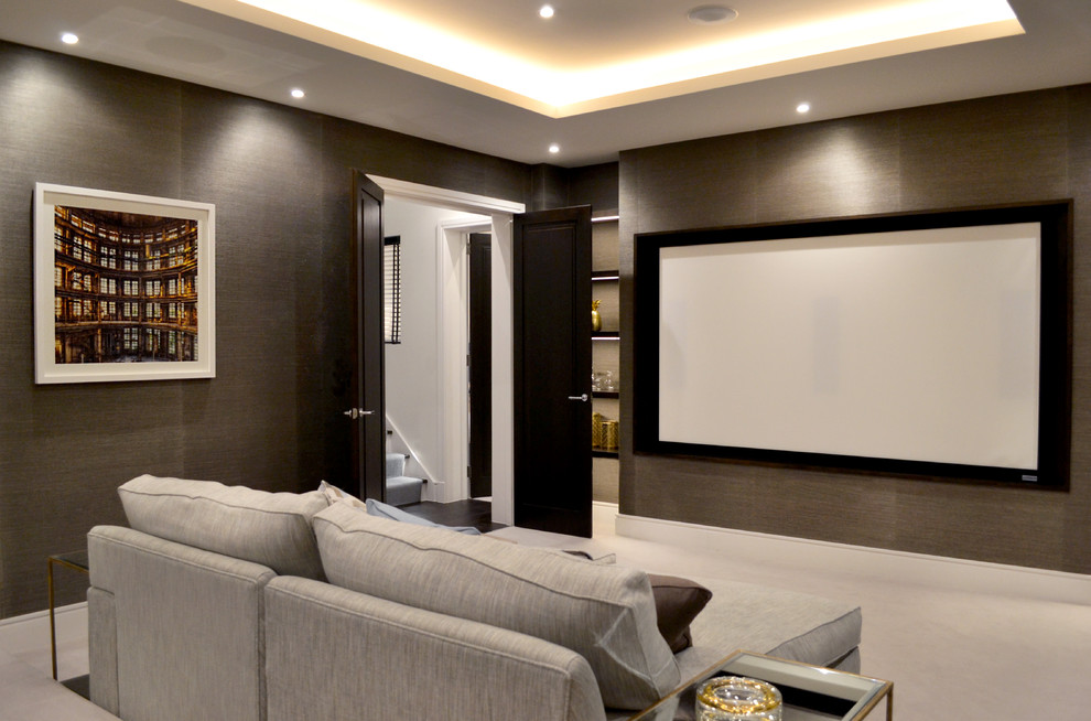 На фото: изолированный домашний кинотеатр среднего размера в современном стиле с коричневыми стенами, ковровым покрытием и телевизором на стене с