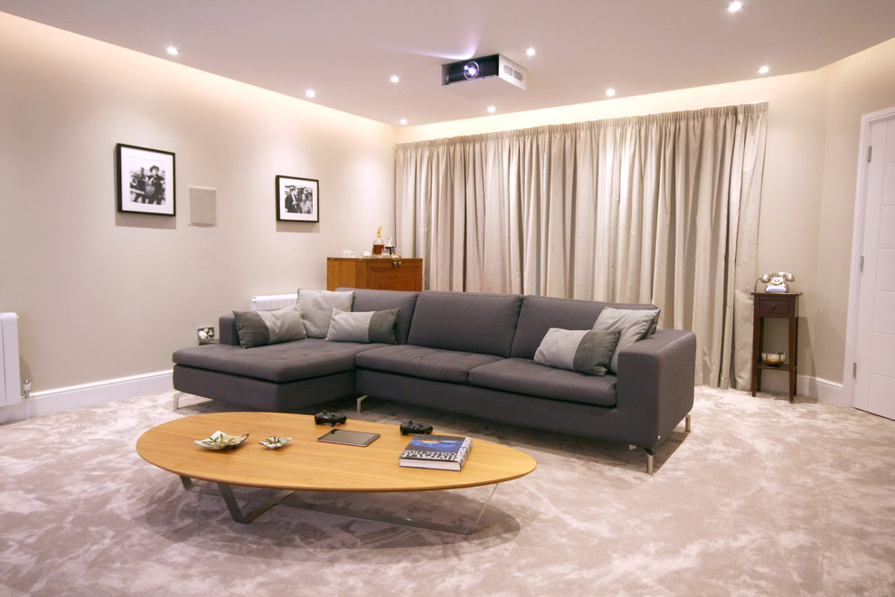 Immagine di un home theatre minimalista di medie dimensioni e chiuso con pareti beige, moquette, pavimento grigio e TV a parete