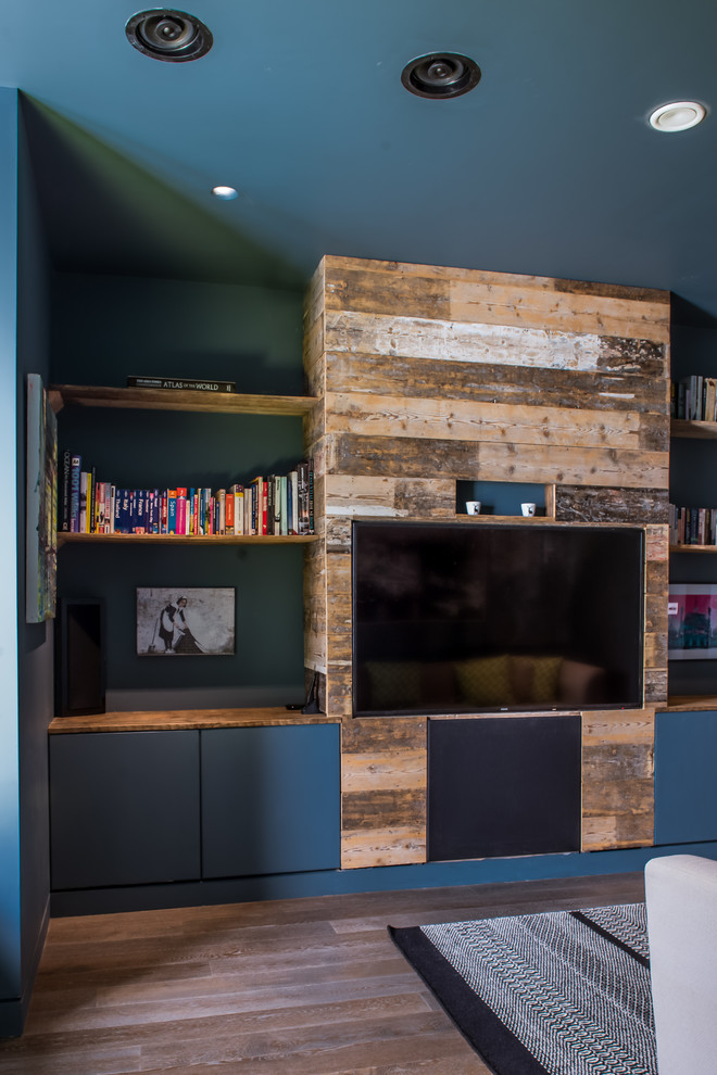 Mittelgroßes, Abgetrenntes Modernes Heimkino mit blauer Wandfarbe, braunem Holzboden und Multimediawand in Sussex