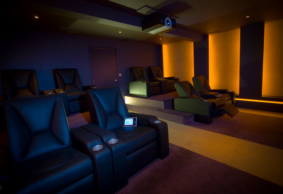 Photo of a large modern enclosed home cinema in Other with purple walls, carpet and a projector screen.