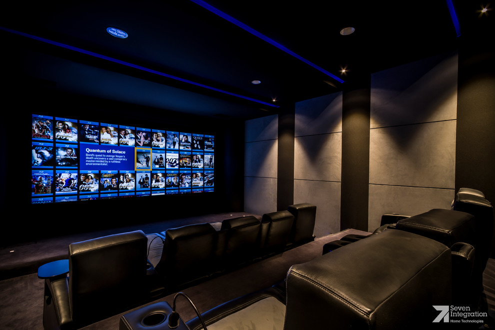 Ejemplo de cine en casa cerrado minimalista de tamaño medio con paredes marrones, moqueta y televisor colgado en la pared