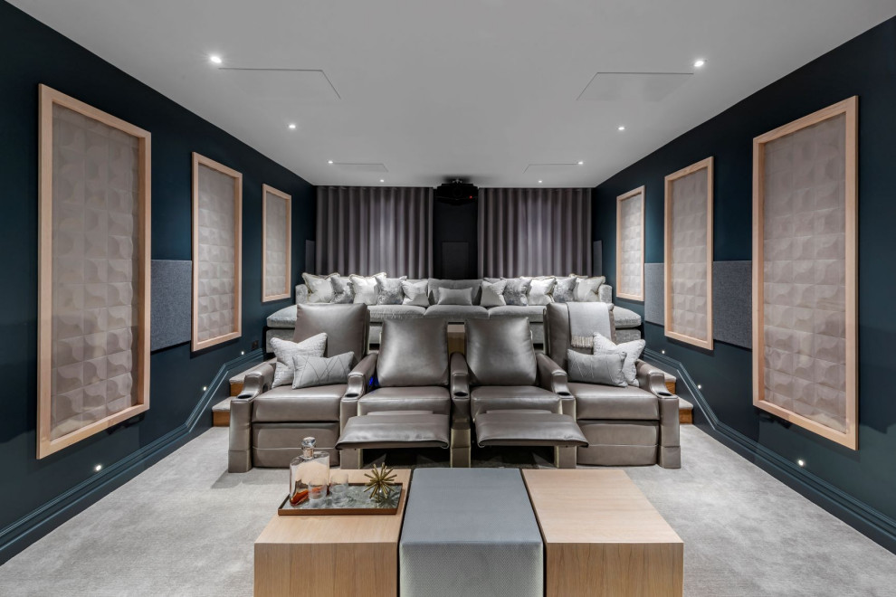 Стильный дизайн: домашний кинотеатр в современном стиле с синими стенами, ковровым покрытием, проектором и серым полом - последний тренд