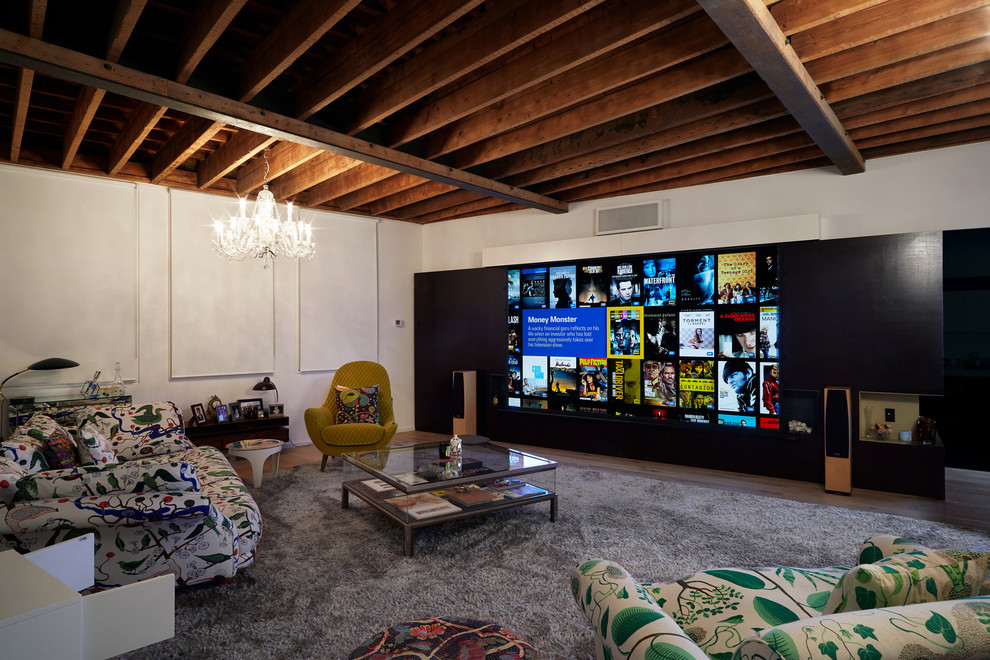 Modelo de cine en casa cerrado ecléctico de tamaño medio con paredes blancas, suelo de madera clara, pantalla de proyección y suelo marrón