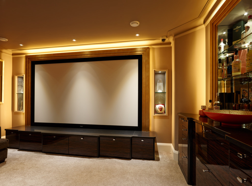 Diseño de cine en casa cerrado actual de tamaño medio con paredes beige, moqueta y pared multimedia
