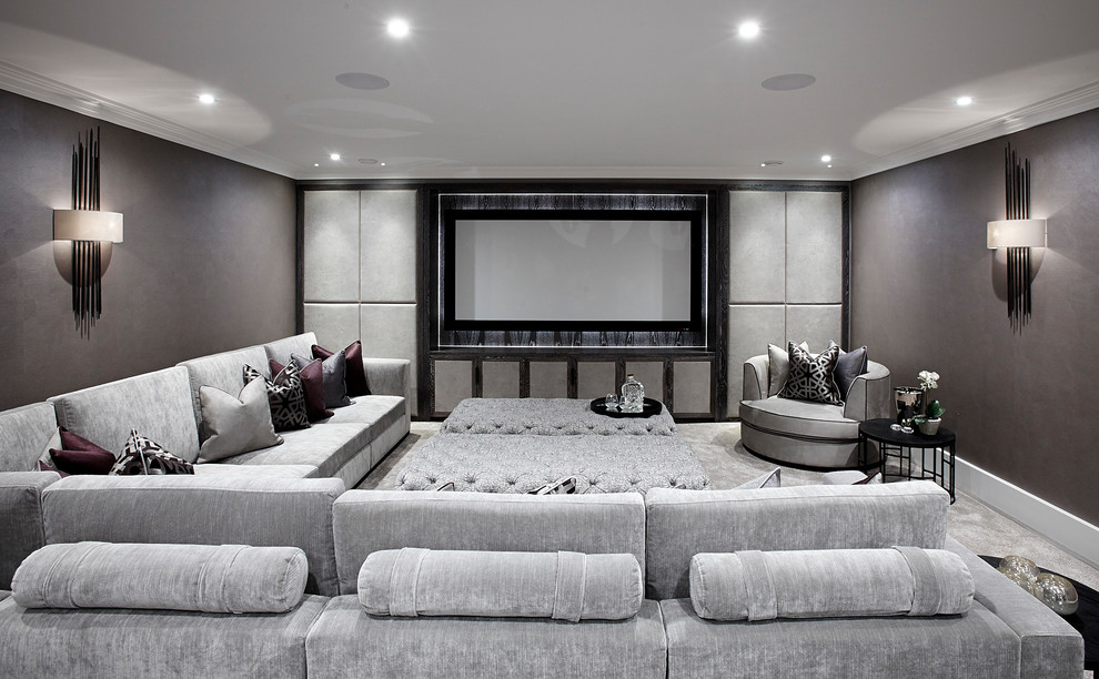 На фото: большой изолированный домашний кинотеатр в стиле неоклассика (современная классика) с серыми стенами, ковровым покрытием, телевизором на стене и серым полом с